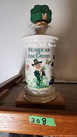 Front view of the Flowers of Ireland liquor bottle with leprechaun and flowers design.
