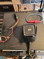 Coiled microphone labeled HRS and wire harness on top of black device surface.