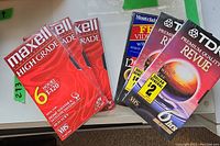 Six unopened VHS video cassette tapes including Maxell High Grade, Montclair FFD120, and TDK Premium Quality Revue in original packaging.