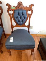 Front view showing full antique wooden side chair with blue upholstered seat and tufted tufted back