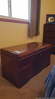 Side view of vintage cedar chest showing smooth, glossy finish and overall shape