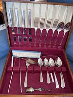 Full view of wooden canteen opened showing neatly arranged Oneida silverplate flatware on velvet lining. Includes knives, forks, spoons, and pie lifter.