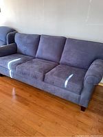 Overall front-left view of blue sofa on hardwood floor