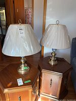 Pair of matching table lamps on wooden furniture showing overall size and design