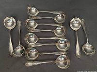 Tray of twelve soup spoons laid out in two rows