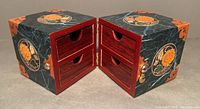Opened box showing two side-by-side doors each revealing two small drawers with half circle pull handles.