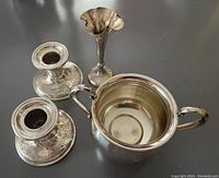 Two short Birks sterling silver candle sticks with EPNS bases, small sterling bud vase, and International Sterling sugar bowl displayed on a dark surface