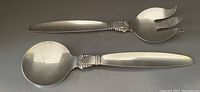 Top view of the salad servers showing the scoop spoon and fork with curved prongs and detailed handle design.