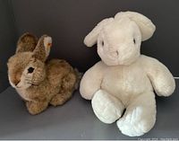 Photo of two sitting bunny plush toys, Steiff Dormili (brown) on left, Gund white bunny on right.