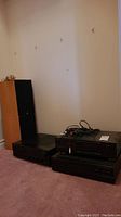 Photo showing the full stereo system setup including two Monitor Audio speakers and stacked Denon components on the right side floor.