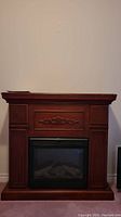 Front view of ChimneyFree electric fireplace with dark wood decorative mantle and inset electric firebox.