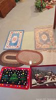 Overview of eight assorted mats laid out on floor showing various shapes, colors, and patterns including braided and floral designs.