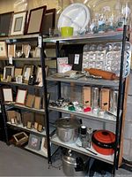 Two metal shelving units with various household items on shelves. Shelves have patterned liners. Showcase shelving size and setup.