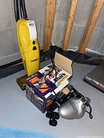 Eureka II upright vacuum and Shark portable handheld vacuum with box and cords visible