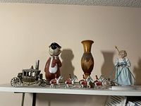 Photo shows the entire lot with the horse-drawn carriage, piggy bank, wooden vase, figurine, and linked horses.