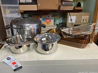 Wide angle of all pots and glass baking dishes showing overall set condition and quantity