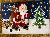Full view of Christmas rug showing Santa skiing with sack and pine tree on navy background.