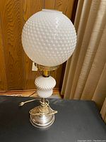 Full view of the vintage milk glass lamp showing hobnail textured white glass globe and matching hobnail base with metal fittings and cord.