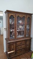 Front view of the full two-piece Spanish style china cabinet and wood hutch set showing overall design including glass doors, wrought iron accents, drawers and cabinets below.