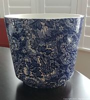 Front view of the blue floral patterned ceramic planter for detail on design and shape.