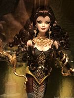 Close-up front view of Medusa Barbie doll inside box showing face, hair and upper outfit.