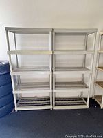 Front view of two gray plastic shelving units each with four slotted shelves, approximately 18 inches wide by 36 inches tall.