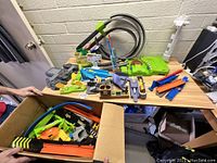 Wide view of assembled and loose Mario Kart Hot Wheels track pieces on table and in box