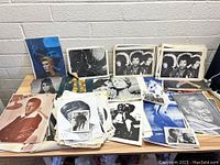 Overview of the lot showing multiple celebrity and cultural figure prints laid out on table