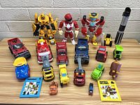 Full lot view showing all toys including action figures, trucks, and puzzles.