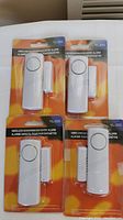 Four wireless door/window entry alarms, model YL-333, all in sealed packaging showing front view.