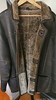 Front view of coat open to show exterior and interior shearling lining