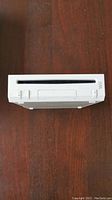 Top view of white Nintendo Wii console showing slot-loading disc drive and control buttons on front face.