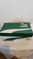 Closed green and white Puma branded shoebox