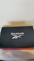 Box top showing Reebok logo in white on black background.