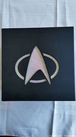 Black Star Trek collector's box with large shiny Starfleet logo on top.