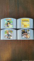 Front view of four grey Nintendo 64 cartridges arranged in two rows showing labels for Diddy Kong Racing, Star Fox 64, Mario Kart 64, NBA Hangtime.