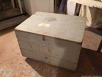 Exterior view of the wooden army shipping crate showing wear, age marks, and sealed top.