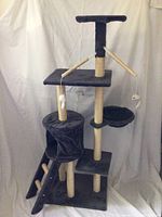 Full view of the black plush multi-level cat tree showing base, cubby, platforms, and hanging toys.