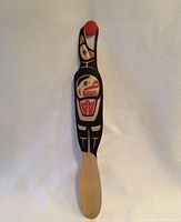 Full length view of the carved wooden raven showing its form and painted details.