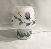 Front and side views of the mushroom-shaped lamp showing the floral painted glass and marbled white finish.