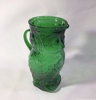Photo showing green glass owl jug front and side angles, highlighting details and condition