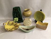 Front view of seven ceramic pieces showing shapes, colors, and finishes.