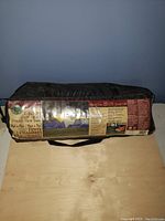 Photo of tent in packaged form with label showing brand, model, and tent features.