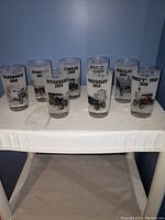 Photo showing all eight antique car-themed shot glasses featuring vintage car illustrations and model years.
