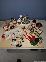 Overview of all Christmas decorations on table, snowmen, ceramic dish, ornaments, felt decor, Santa figurines