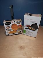 Two boxed breakfast kitchen tools: Gotham Pancake Bonanza Dipper and Omelet Pan & Egg Poacher