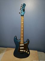Full front view of the blue Stagg electric guitar showing body, neck, and headstock with six strings and three pickups.