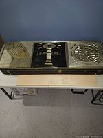 Closed hard shell case showing decorative metal panels on exterior