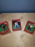 Three boxed Elvis Presley Christmas ornaments displayed on a wooden table, showing the front of the boxes and the branding.
