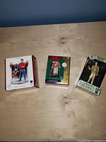 Three boxed Elvis Presley Christmas ornaments displayed side by side